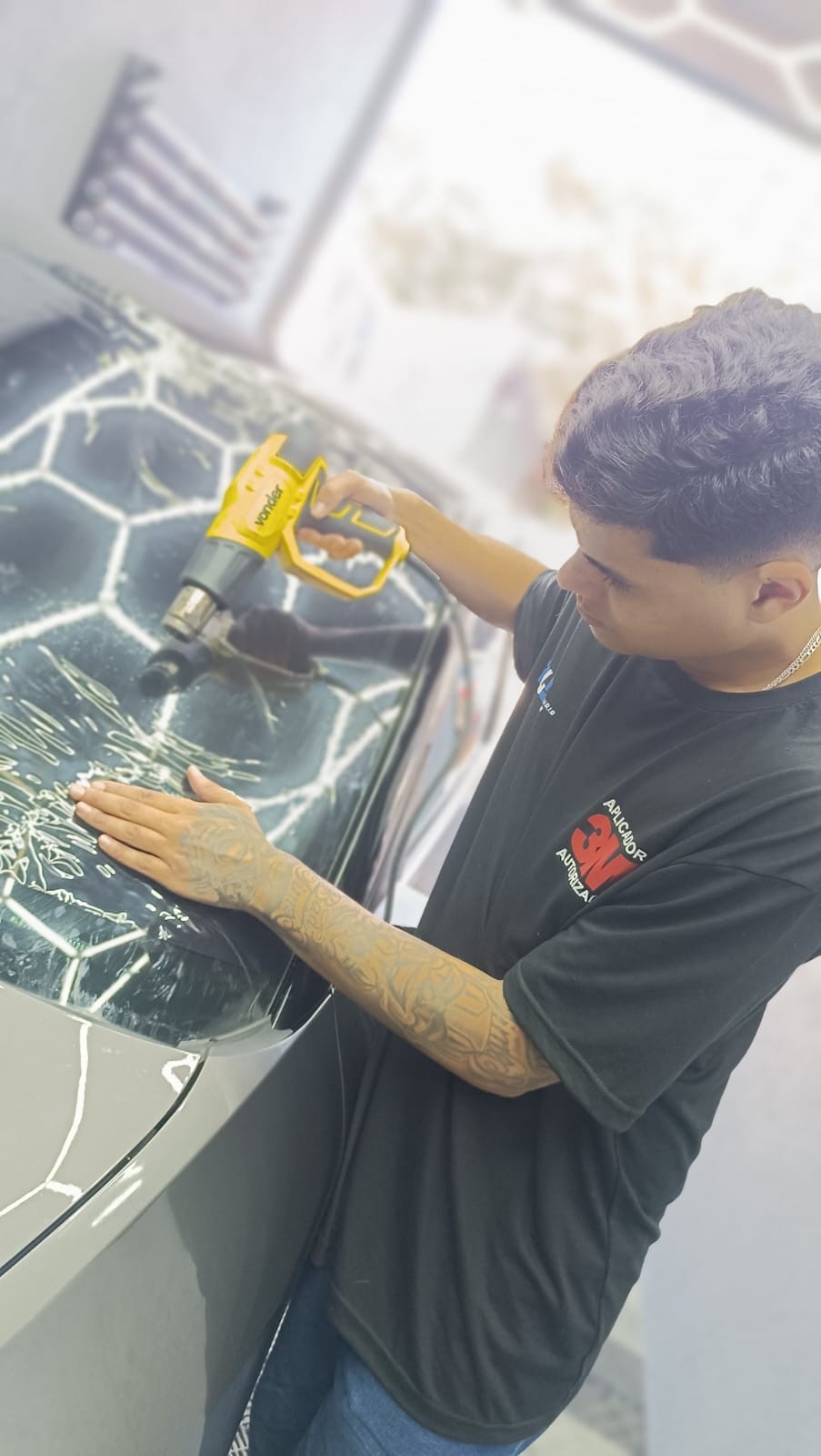 Técnico aplicando insulfilm no para-brisa